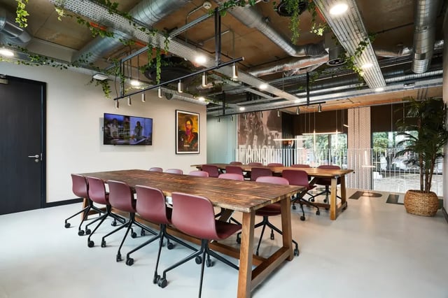 Large wooden tables with red chairs common area at Vita Student St.Albans in Leeds Student Accommodation