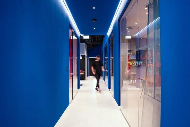 Person walks down bright blue hallway communal area at Vita Student Copper Towers in Coventry Student Accommodation