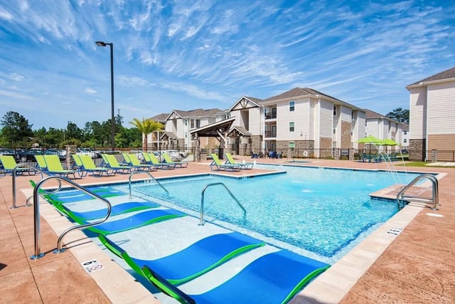 Pool with lounge chairs and buildings exterior at Waypoint at Hammond in Hammond Student Accommodation