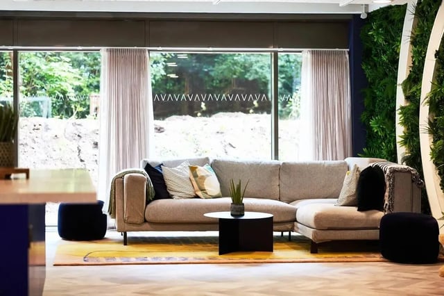 Sectional couch black ottoman plants living room at Vita Student Cannon Park Warwick in Coventry Student Accommodation