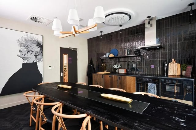 Large black table with chairs artwork kitchen area dining room at Vita Student Portland Crescent in Leeds Student Accommodation
