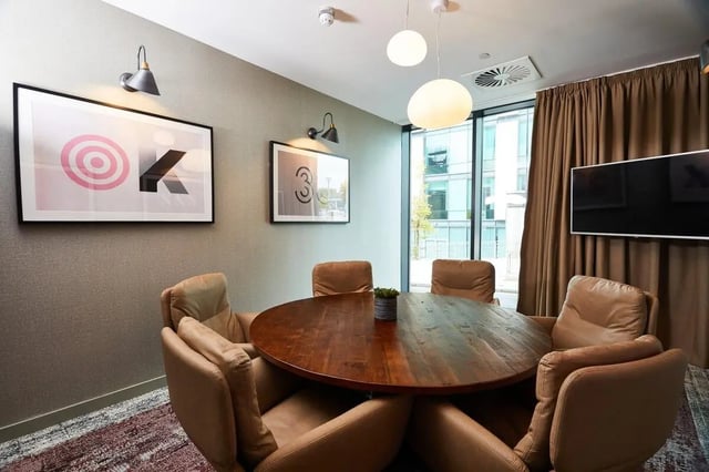 Round table brown chairs artwork and TV communal area at Vita Student Portland Crescent in Leeds Student Accommodation