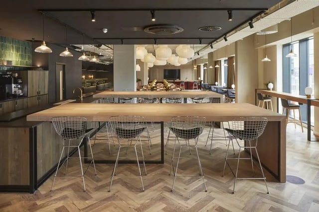 Large communal table with bar stools kitchen area at Vita Student Portland Crescent in Leeds Student Accommodation