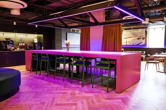 Pink counter with green stools and coffee bar communal area at Vita Student Park Place in Cardiff Student Accommodation