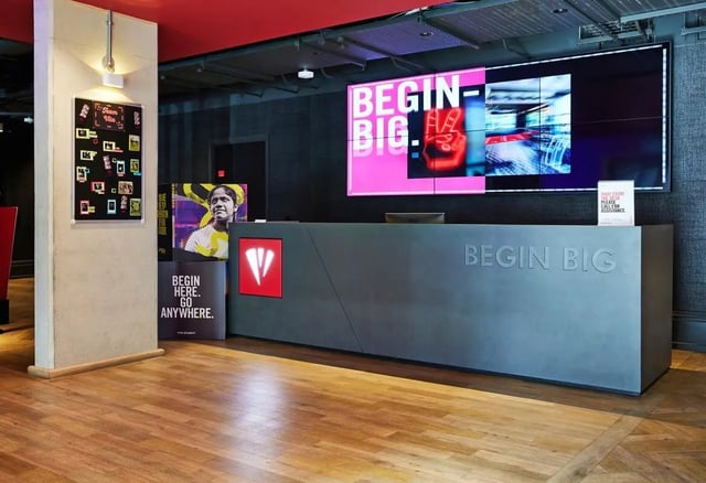Reception desk with large screen and posters Lobby at Vita Student Park Place in Cardiff Student Accommodation