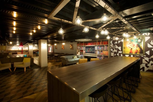 Long counter with stools and sofas living room at Vita Student Crosshall Street in Liverpool Student Accommodation