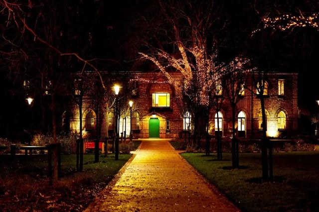 Brick building with illuminated windows and green door Exterior at Vita Student Lawrence Street in York Student Accommodation