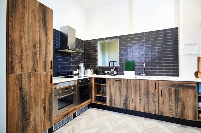 Modern kitchen with wooden cabinets and dark tile. Kitchen at Vita Student Lawrence Street in York Student Accommodation