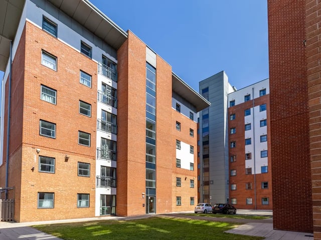 Brick apartment buildings with balconies cars outside exterior at Europa in Liverpool Student Accommodation