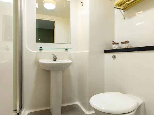Sink toilet shower with towels and jars bathroom at Europa in Liverpool Student Accommodation