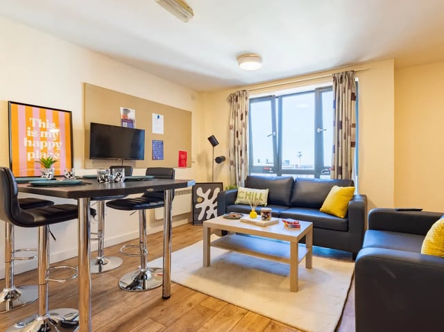 Sofa coffee table chairs and TV living room at Europa in Liverpool Student Accommodation