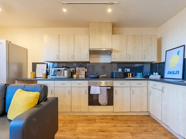 Fridge microwave oven cabinets yellow pillow kitchen at Europa in Liverpool Student Accommodation
