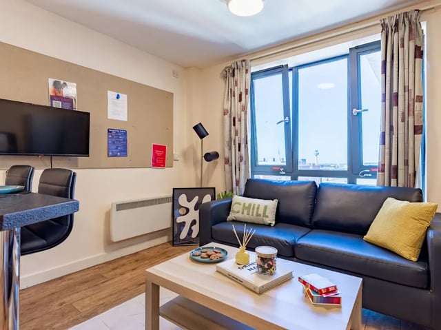 Dark sofa with pillows coffee table living room at Europa in Liverpool Student Accommodation