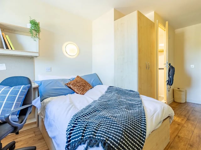 Bed with blue pillows closet and chair bedroom at Europa in Liverpool Student Accommodation