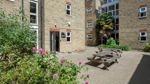 Picnic tables near brick building exterior at Dean House in London Student Accommodation