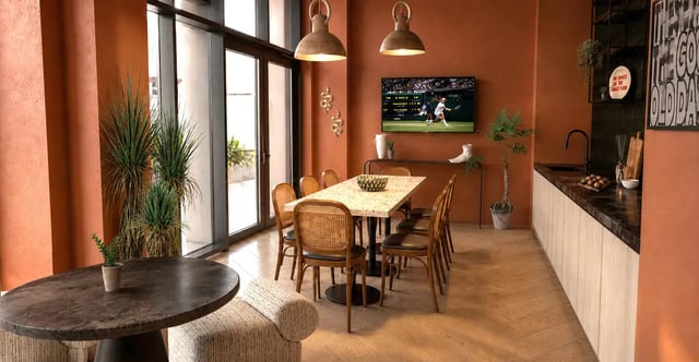 Dining table chairs television and kitchen counter Kitchen at Compass in Birmingham Student Accommodation