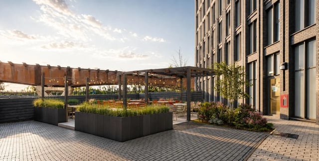 Outdoor patio with tables chairs and string lights exterior at Compass in Birmingham Student Accommodation