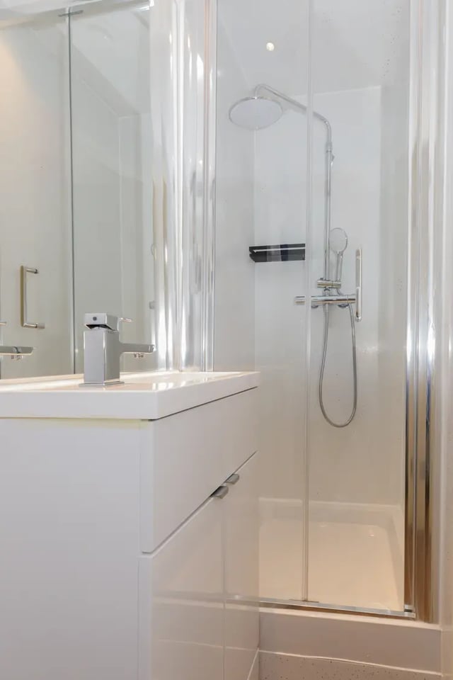 White vanity with sink and chrome shower stall bathroom at The Stay Club - Kentish Town in London Student Accommodation