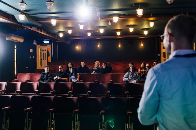 Audience watching presentation in plush seating area auditorium at The Stay Club - Kentish Town in London Student Accommodation
