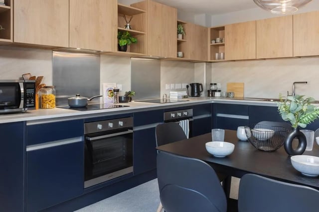 Modern kitchen with dark blue cabinets and dining table Kitchen at St Peters Court in Nottingham Student Accommodation