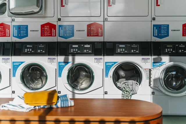 Row of washers and dryers with table laundry area at City Wharf in Glasgow Student Accommodation