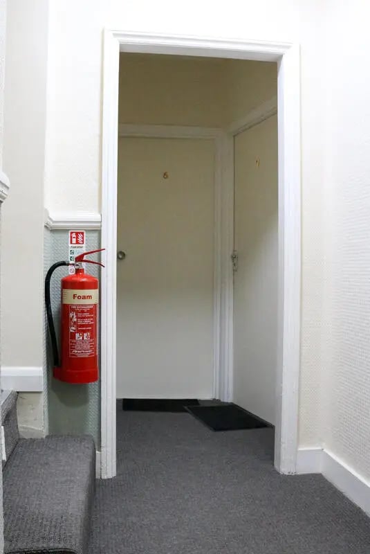 Fire extinguisher and doors in hallway interior at 42 Disraeli Rd E7 9JP in London Student Accommodation