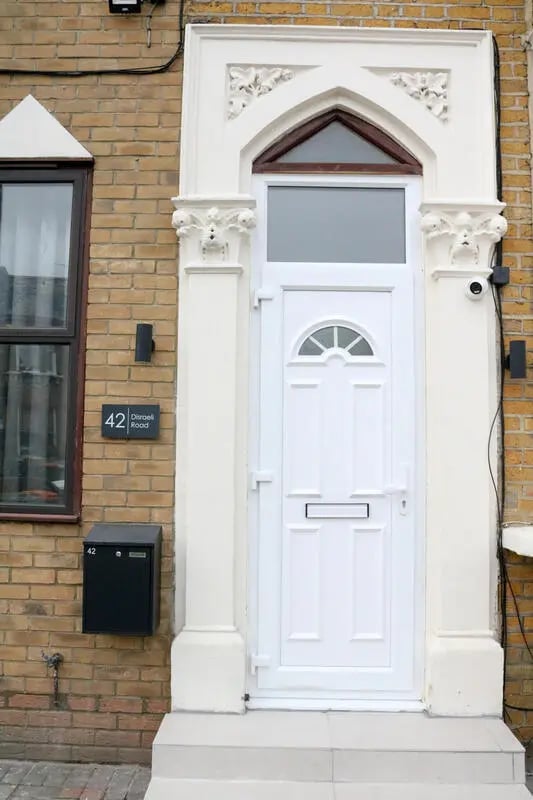 White front door with arched window and security camera Exterior at 42 Disraeli Rd E7 9JP in London Student Accommodation