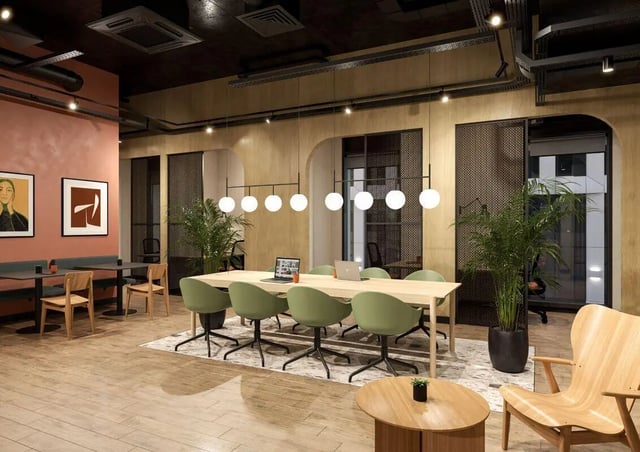Modern common area with tables chairs and plants study area at Fusion Leeds in Leeds Student Accommodation