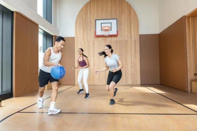 Students playing basketball on wooden court recreation area at Fusion Students Brent Cross in London Student Accommodation