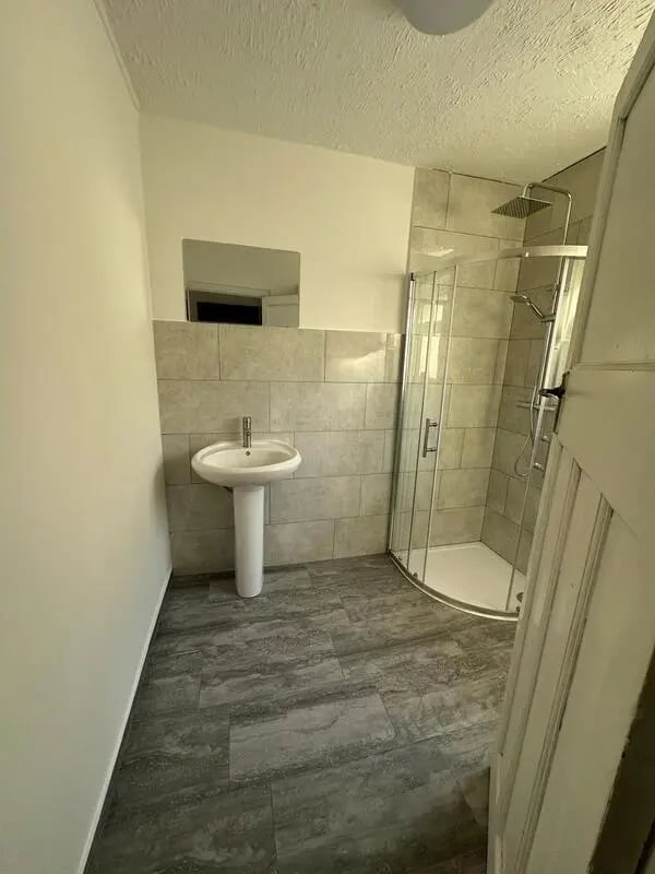 Pedestal sink shower stall tile floor bathroom at E16 3LL, MacGregor Rd, London in London Student Accommodation