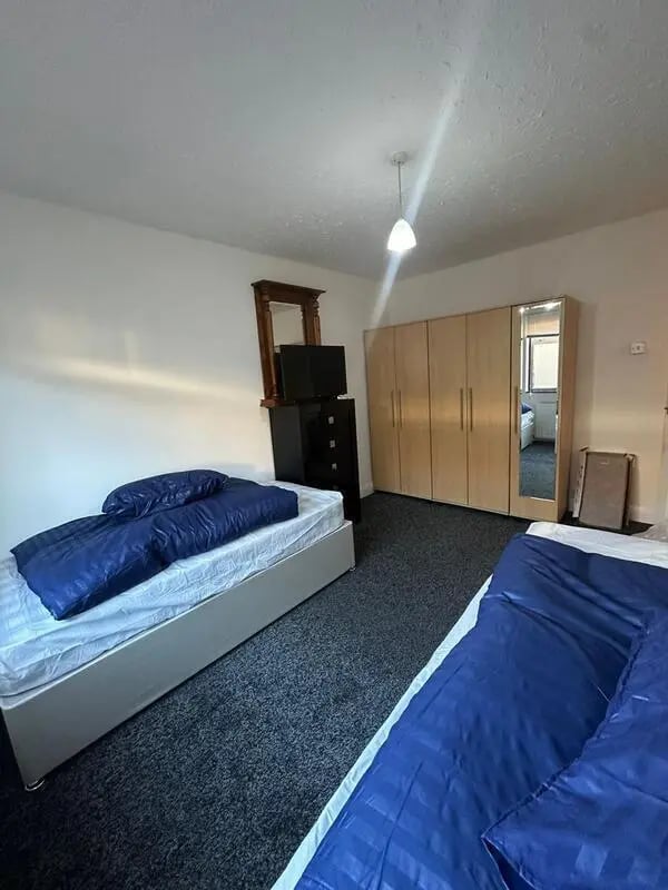 Two beds mirrored wardrobe television dresser bedroom at E16 3LL, MacGregor Rd, London in London Student Accommodation