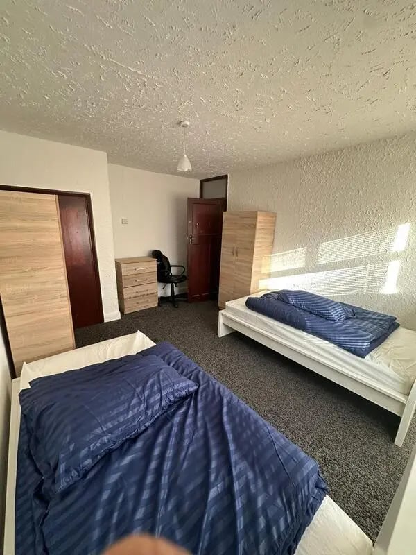 Two beds wardrobe desk and chair bedroom at E16 3LL, MacGregor Rd, London in London Student Accommodation