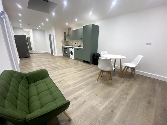 Green sofa dining table and kitchen area living room at E7 8PF, Shaftsbury Rd, London in London Student Accommodation