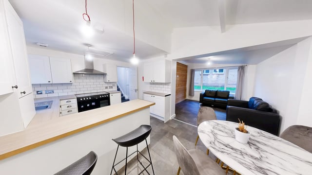 Kitchen with modern counters sofa living area and table living area at Park Village in Sheffield Student Accommodation