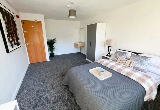 Bed with patterned throw wardrobe vanity sink bedroom at Clanny House in Sunderland Student Accommodation