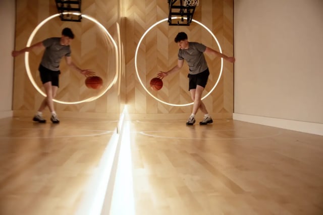 Young man dribbling basketball wooden court basketball area at Fusion Students Liverpool in Liverpool Student Accommodation