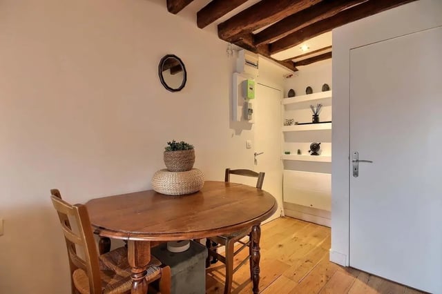 Wooden table chairs plant and shelves dining area at Studio in Rue de Bourgogne, 75007 Paris, France in Paris Student Accommodation