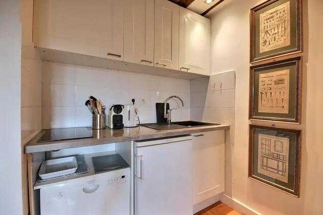 Kitchenette with appliances cabinets sink and artwork Kitchen at Studio in Rue de Bourgogne, 75007 Paris, France in Paris Student Accommodation