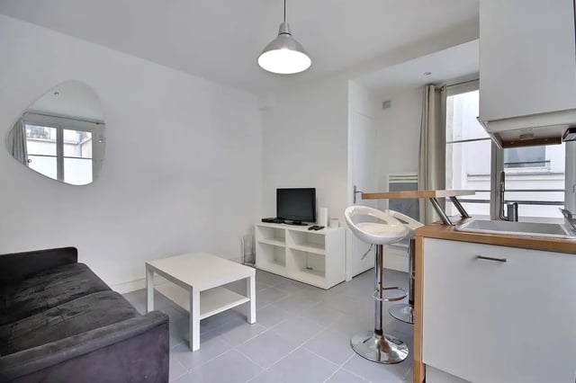 Sofa coffee table TV bar stools kitchen living room at Apartment in Rue Keller, 75011 Paris, France in Paris Student Accommodation