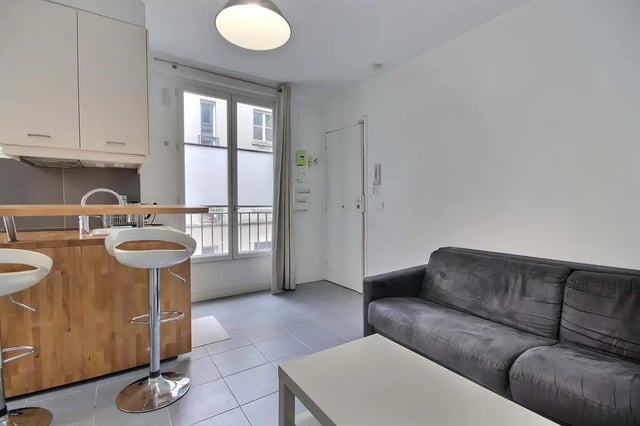 Sofa and bar stools in living room kitchen living room at Apartment in Rue Keller, 75011 Paris, France in Paris Student Accommodation