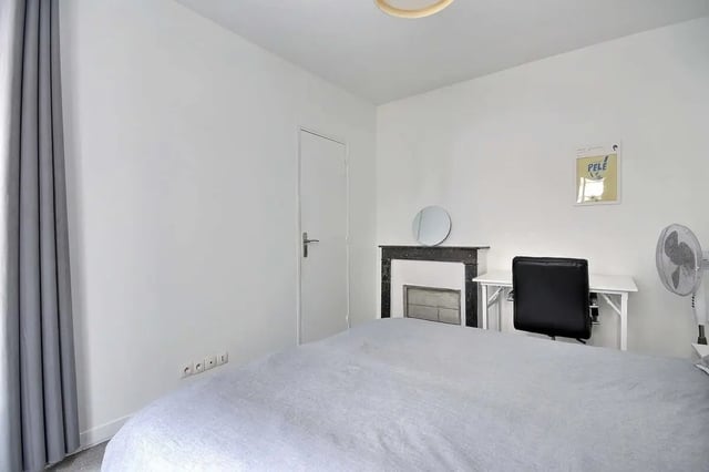 Bed desk fireplace and fan bedroom at Apartment in Rue Keller, 75011 Paris, France in Paris Student Accommodation