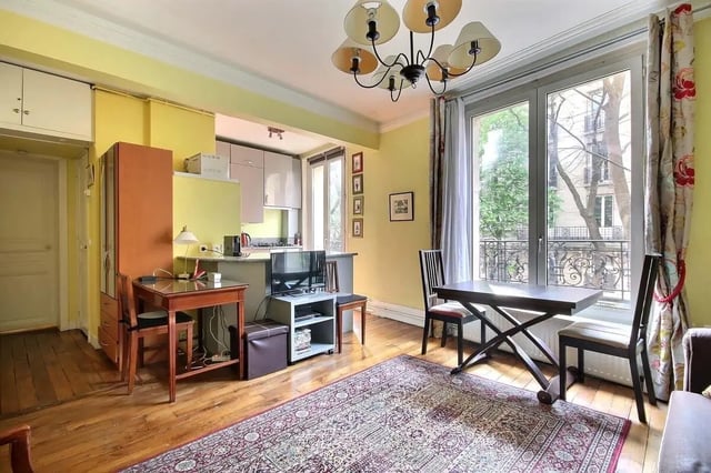 Desk chairs kitchen television and rug living room at Apartment in Rue Caulaincourt, 75018 Paris, France in Paris Student Accommodation