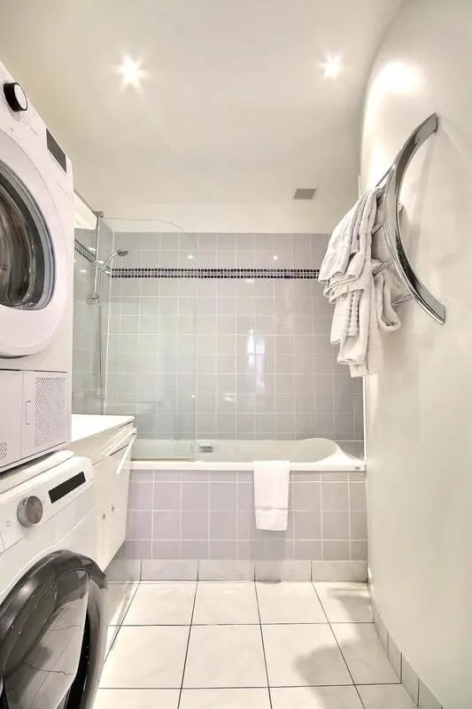 Washing machines and bathtub with tiled walls Bathroom at Apartment in Rue Caulaincourt, 75018 Paris, France in Paris Student Accommodation
