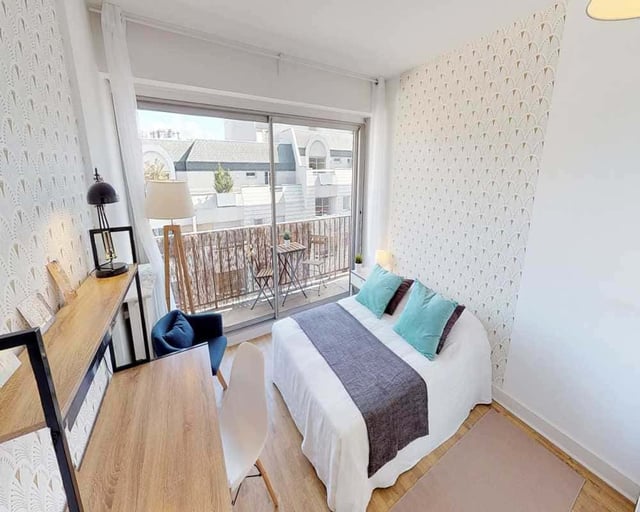 Desk chair bed with blue pillows balcony bedroom at Room in 33 Rue d'Hautpoul, 75019 Paris, France in Paris Student Accommodation