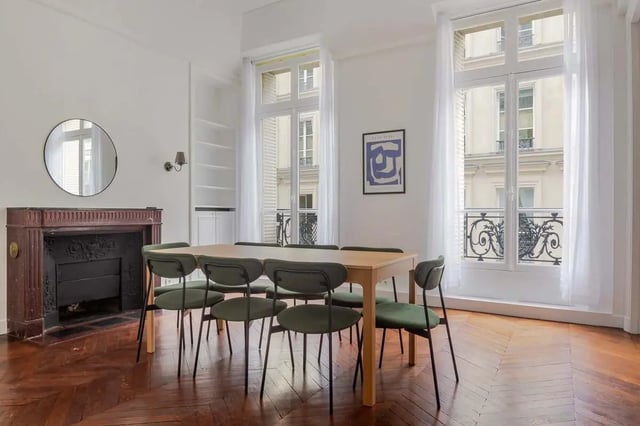 Dining table with green chairs fireplace mirror living room at Apartment in 2 Rue de Miromesnil, 75008 Paris, France in Paris Student Accommodation
