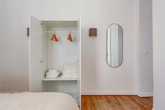 White open wardrobe with folded towels and hangers bedroom at Apartment in 2 Rue de Miromesnil, 75008 Paris, France in Paris Student Accommodation