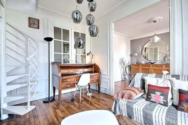 Spiral staircase antique desk patterned sofa living room at Apartment in Rue Régis, 75006 Paris, France in Paris Student Accommodation