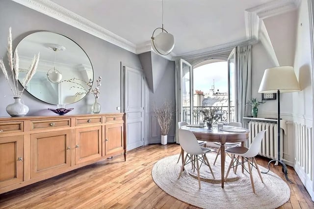 Wooden sideboard circular mirror dining table chairs living area at Apartment in Rue Régis, 75006 Paris, France in Paris Student Accommodation