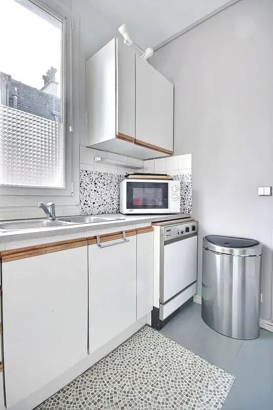 White cabinets microwave dishwasher bin kitchen at Apartment in Rue Régis, 75006 Paris, France in Paris Student Accommodation