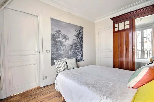 Bed with landscape tapestry wooden wardrobe Bedroom at Apartment in Rue Régis, 75006 Paris, France in Paris Student Accommodation
